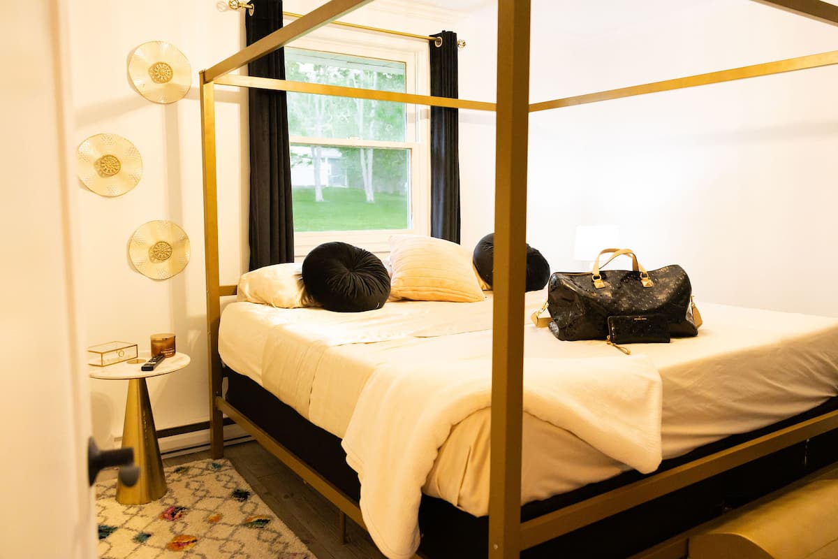 A bedroom with a black canopy bed
